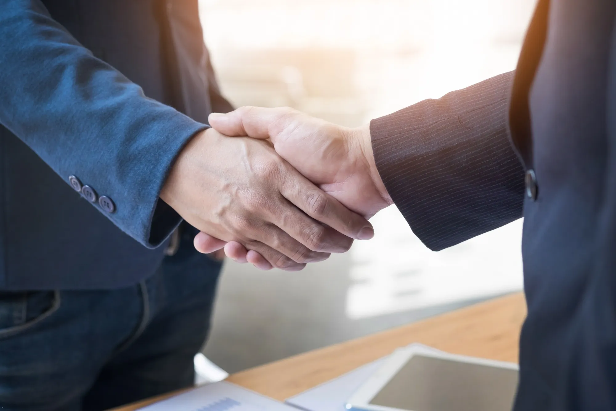 two-confident-business-man-shaking-hands-meeting-office-success-dealing-greeting-partner-concept (1) two confident business man shaking hands meeting office success dealing greeting partner concept 1